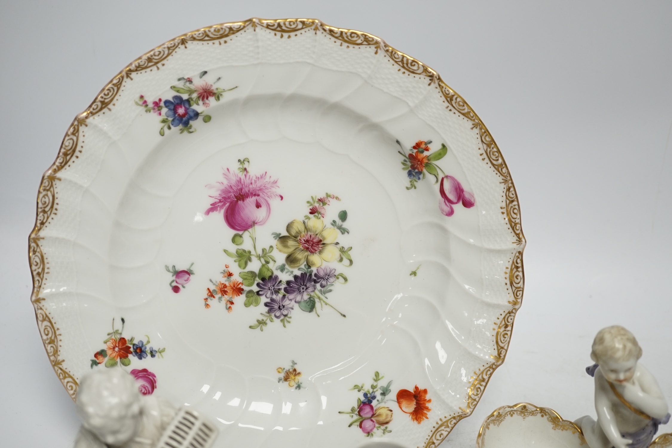 A group of Berlin and German porcelain: a plate, two salts, a figure and a tea canister, tallest figure 13.5cm high. Condition - fair to good.